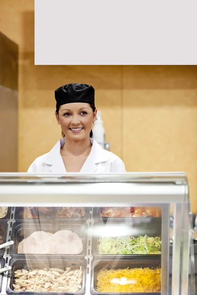 Porträtt av en söt bagare som ler mot en kund i en cafeteria — Stockfoto