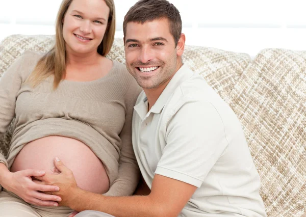 Glad framtida mamma och pappa avkopplande i deras vardagsrum — Stockfoto