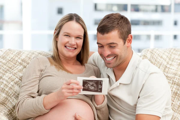 Vackra gravid kvinna visar hennes nukleärmagnetisk till maken — Stockfoto