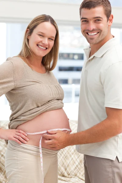 Adorabili futuri genitori con un metro a nastro — Foto Stock