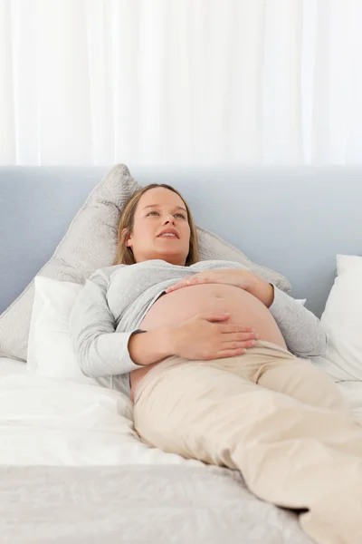 Mulher muito grávida descansando em uma cama — Fotografia de Stock