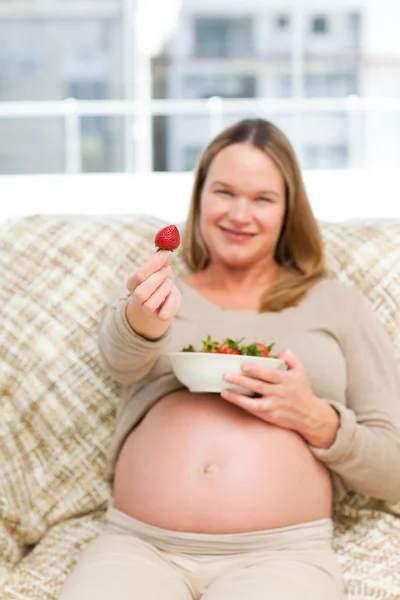 搞笑未来妈妈吃草莓在沙发上休息 — ストック写真