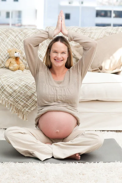 Bela futura mãe fazendo posição de ioga no chão — Fotografia de Stock