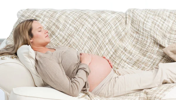 Donna incinta addormentata sdraiata sul divano — Foto Stock
