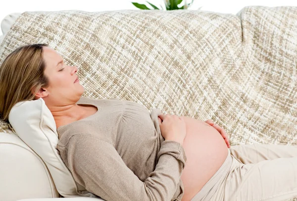 累了怀孕的女人在她沙发上放松 — 图库照片