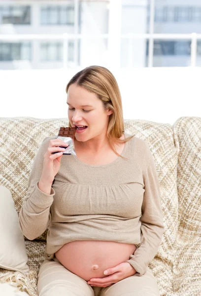 Радостная беременная женщина наслаждается шоколадом во время отдыха — стоковое фото