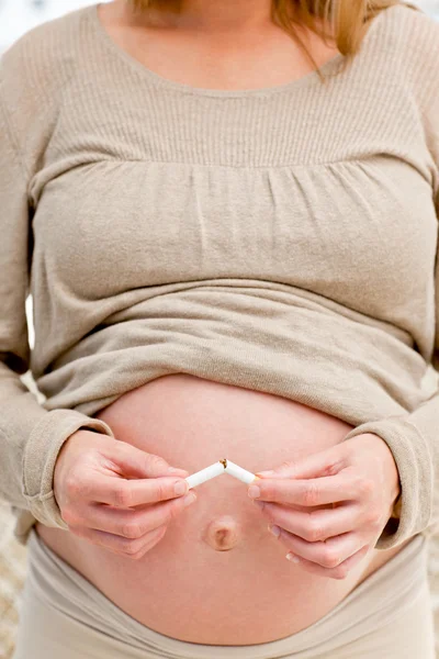 Boa mulher grávida quebrando um cigarro — Fotografia de Stock