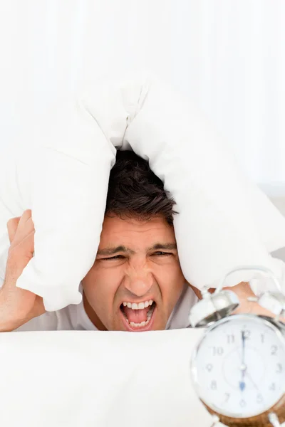 Unhappy man screaming while his alarm clock ringing — Stock Photo, Image