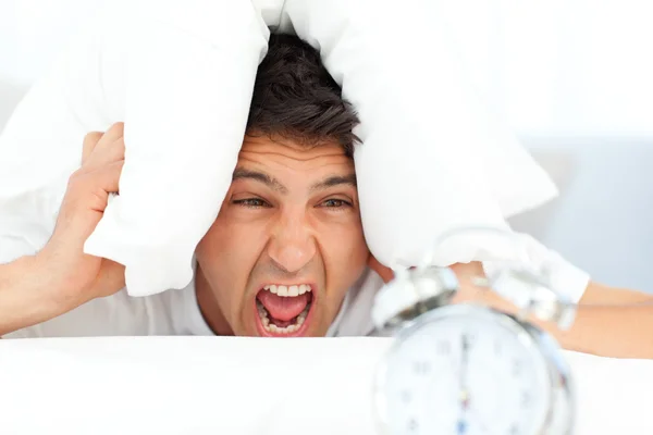 Angry man putting his head under the pillow — Stock Photo, Image
