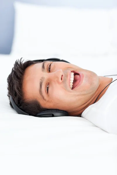 Hombre guapo riendo mientras escucha música —  Fotos de Stock