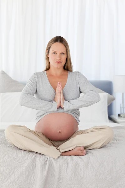 Femme enceinte sérieuse faisant du yoga — Photo