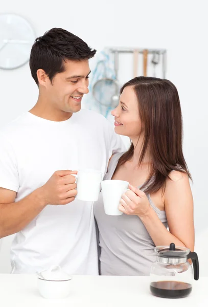 Прекрасная пара, держащая чашки кофе и глядя друг на друга — стоковое фото