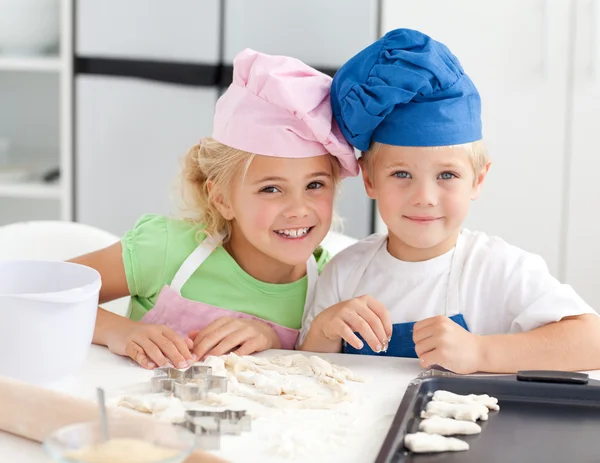 2 つのかわいい子供たちはキッチンでベーキングの肖像画 — ストック写真