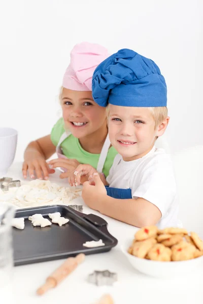 Adorable siblings kneading together a dough in the kitche — Stock Photo, Image