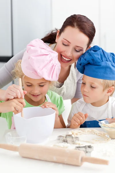 Mãe com seus filhos cozinhando juntos na cozinha — Fotografia de Stock