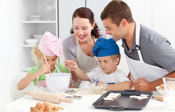 Feliz familia cocinando una crema juntos en la cocina —  Fotos de Stock