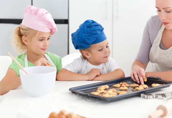Irmãos e sua mãe degustando seus biscoitos — Fotografia de Stock