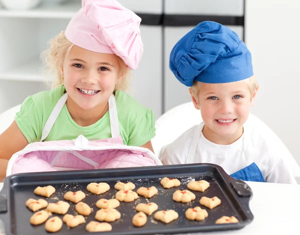 Happy little brother and sister with their biscuits ready to eat — Stock Photo, Image