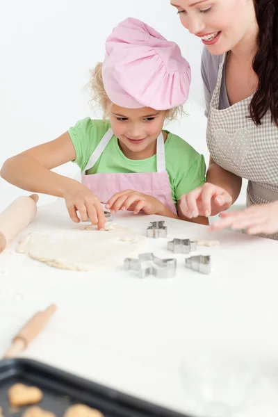 Cute daughter and her beautiful mother making cookies using baki — Stock Photo, Image