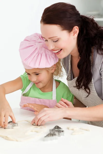 Happy mother and daughter cooking biscuits together — Stock Photo, Image