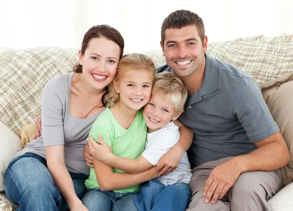 Família feliz sentada no sofá — Fotografia de Stock