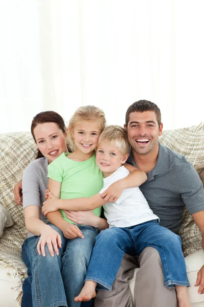 Радостная семья сидит на диване — стоковое фото