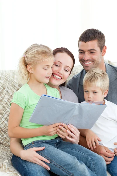 Entzückende Familie beim gemeinsamen Lesen eines Buches im Wohnzimmer — Stockfoto
