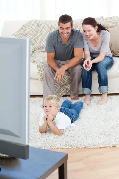 Lindo niño viendo la televisión en el suelo con sus padres —  Fotos de Stock