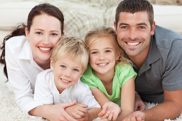 Family looking at the camera on the floor — Stock Photo, Image