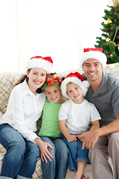リビング ルームに座っているクリスマスに愛らしい家族 — ストック写真