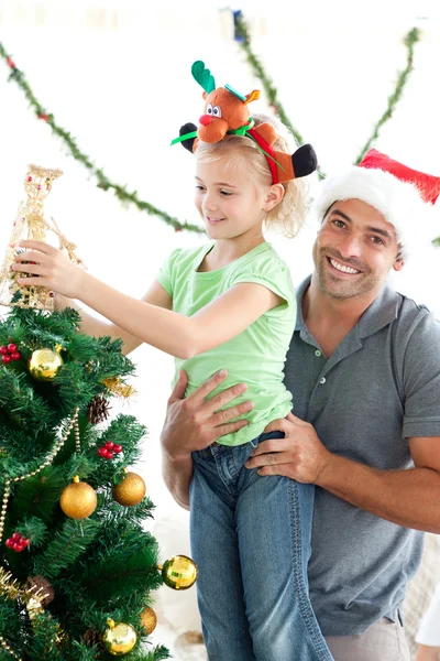 Счастливый отец помогает своей дочери поставить ангела на Рождество — стоковое фото
