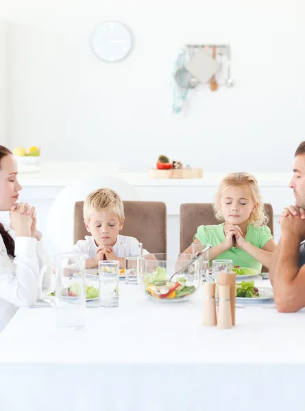 Родители и их дети молятся во время обеда — стоковое фото