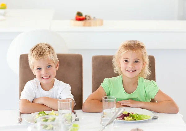Glad bror och syster under lunch i köket — Stockfoto