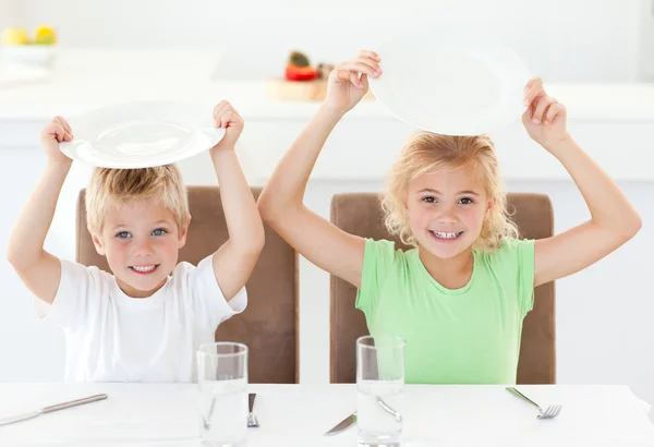 Engraçado irmão e irmã pedindo seu almoço levantando seu pl — Fotografia de Stock