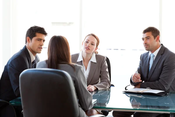 Visão traseira de uma empresária sendo entrevistada por três executivos — Fotografia de Stock