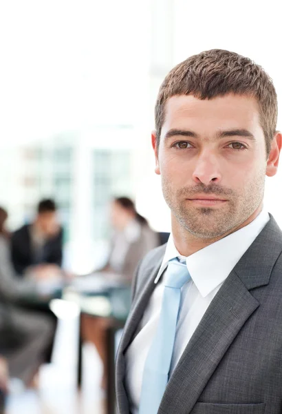 Charismatic businessman standing in the foreground — Stock Photo, Image