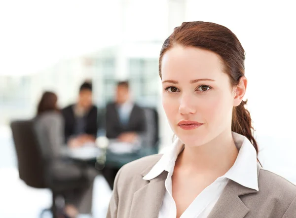 Charismatic businesswoman standing in the foreground while her t — Stock Photo, Image