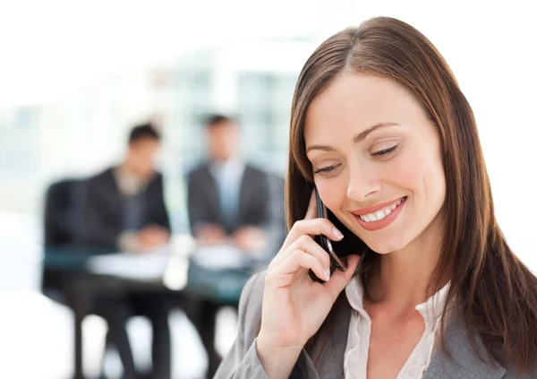 Pretty businesswoman on the phone while her team is working — Stock Photo, Image