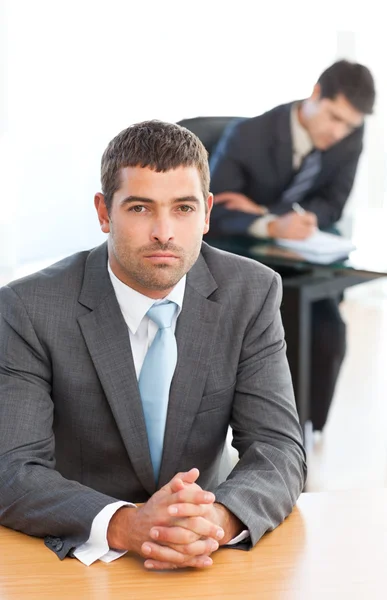 Karismatisk affärsman sitter i förgrunden medan hans coll — Stockfoto