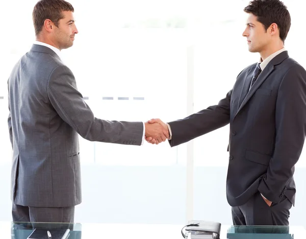 Ernstige zakenlieden schudden hun handen na afloop van een vergadering — Stockfoto