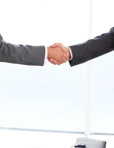 Крупным планом два бизнесмена пожимают руки стоя в — стоковое фото
