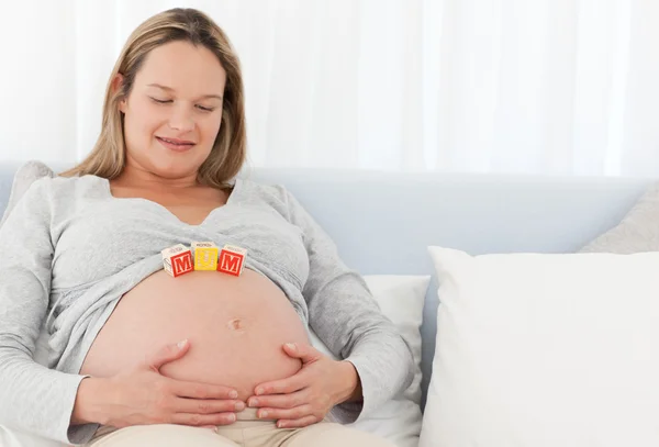 Vrij zwangere vrouw met letters op haar buik — Stockfoto