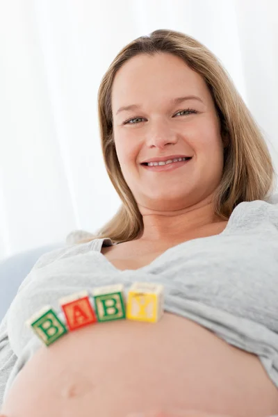 Porträt einer zukünftigen Mutter mit Babybriefen auf dem Bauch — Stockfoto