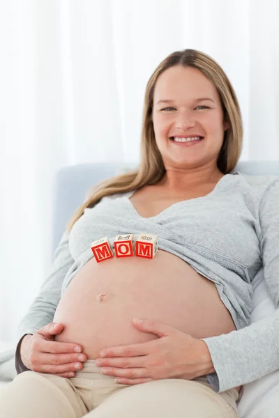 Adorable femme avec des lettres de maman sur le ventre — Photo