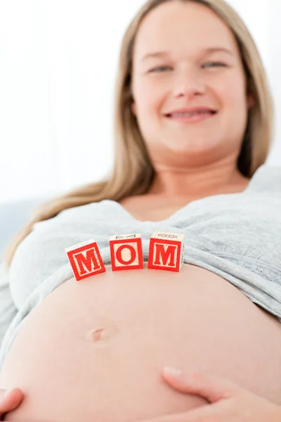 Zamknij z kobietą o mama litery na jej brzuch leżąc na b — Zdjęcie stockowe
