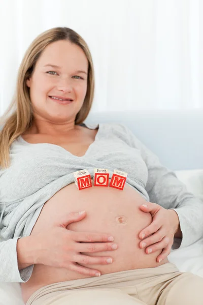 Joven alegre con cartas de mamá en su vientre — Foto de Stock