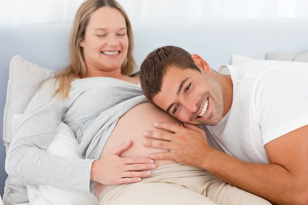 Ευτυχισμένος μελλοντικός μπαμπάς να ακούει την κοιλιά της εγκύου γυναίκας του — Φωτογραφία Αρχείου