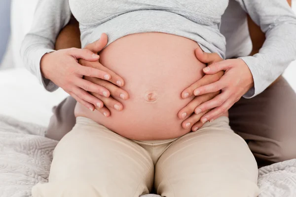 Крупным планом пара трогает живот беременной женщины — стоковое фото