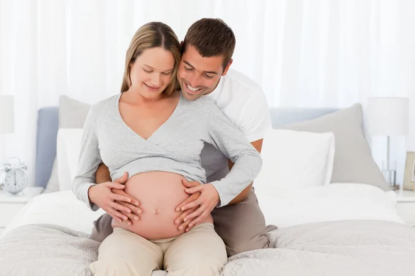Entzückende zukünftige Mama und Papa fühlen den Bauch der Frau — Stockfoto