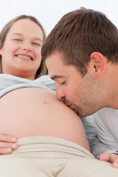 Szczęśliwy człowiek, całowanie brzucha żony w ciąży podczas relaksu — Zdjęcie stockowe